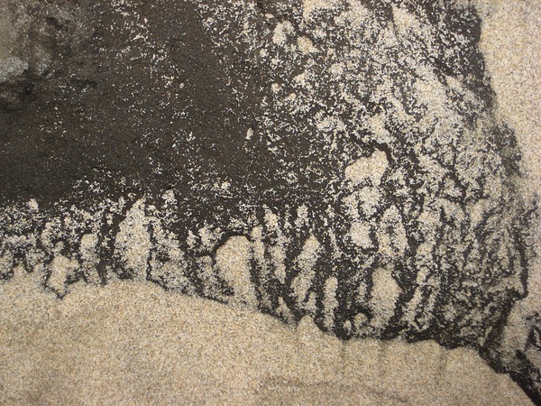 Sand on dark rock